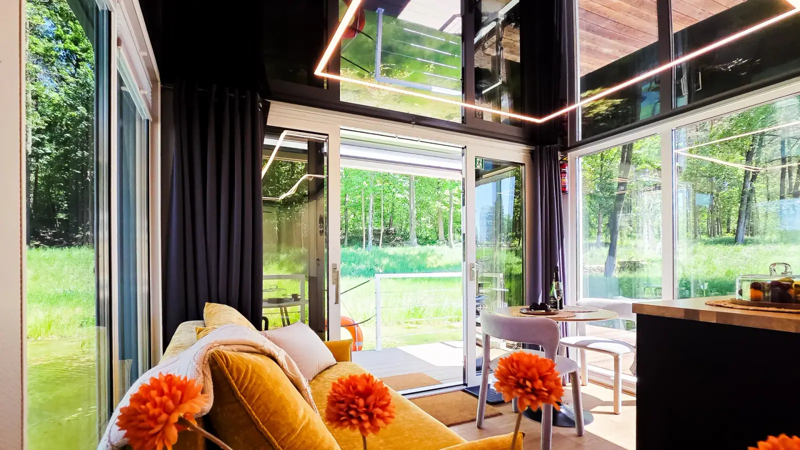Salon lumineux d’un houseboat avec baies vitrées panoramiques